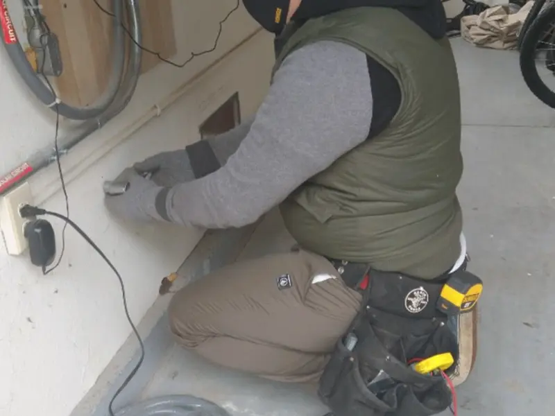 Electrician performing outlet wiring in a Berlin garage